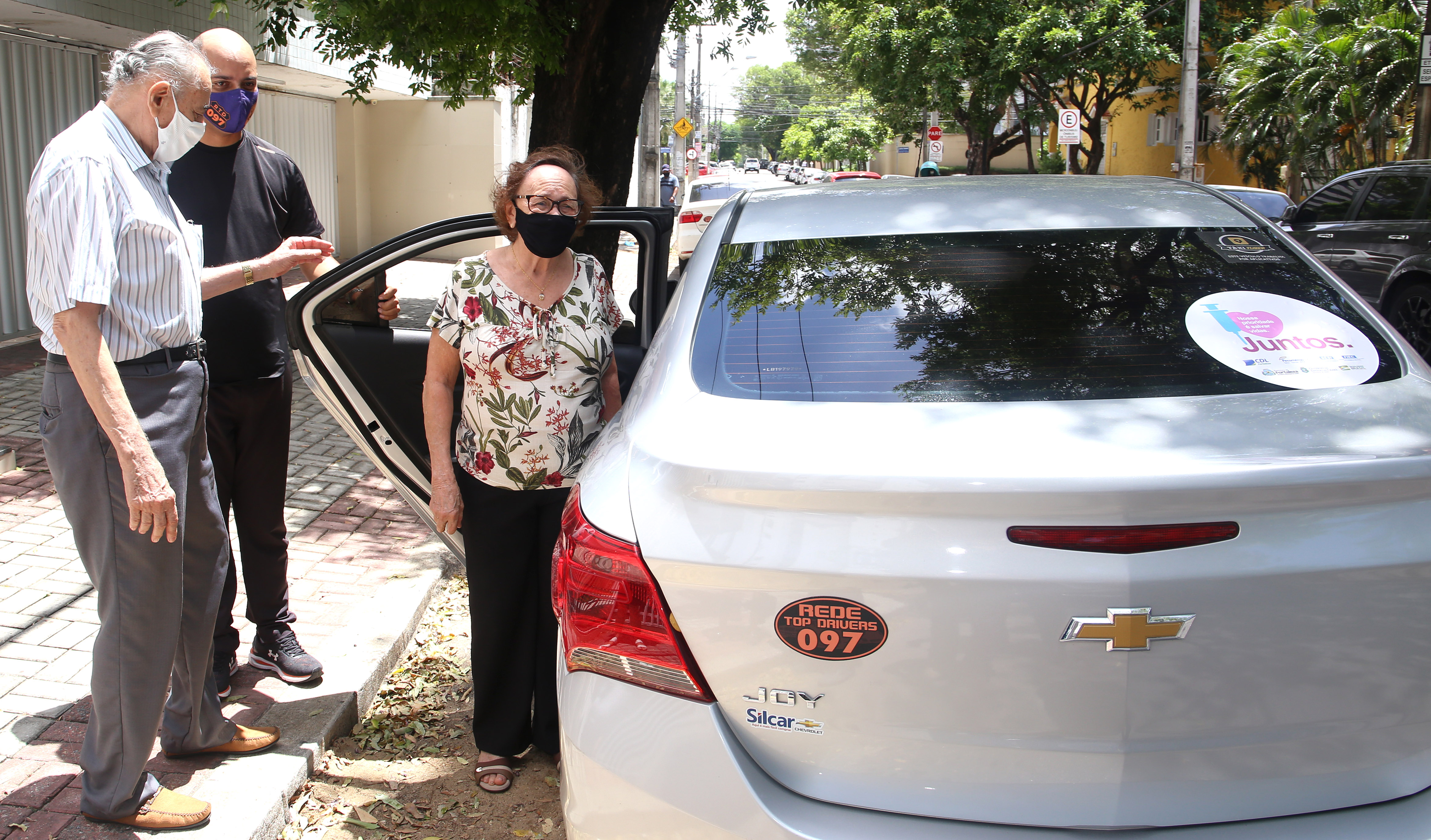 uma senhor e uma senhora entra em um carro